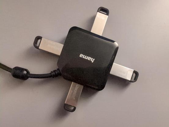 Vier silbrige USB-Sticks (Kingston Kyson, 64 GB) stecken in einem USB-Hub.
