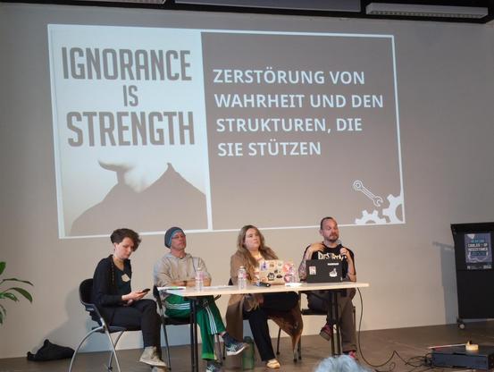 Folie mit dem 1984-Zitat »Ignorance is strength« neben dem Text »Zerstörung von Wahrheit und den Strukturen, die sie stützen« (als Folge des Einsatzes generativer »KI«)